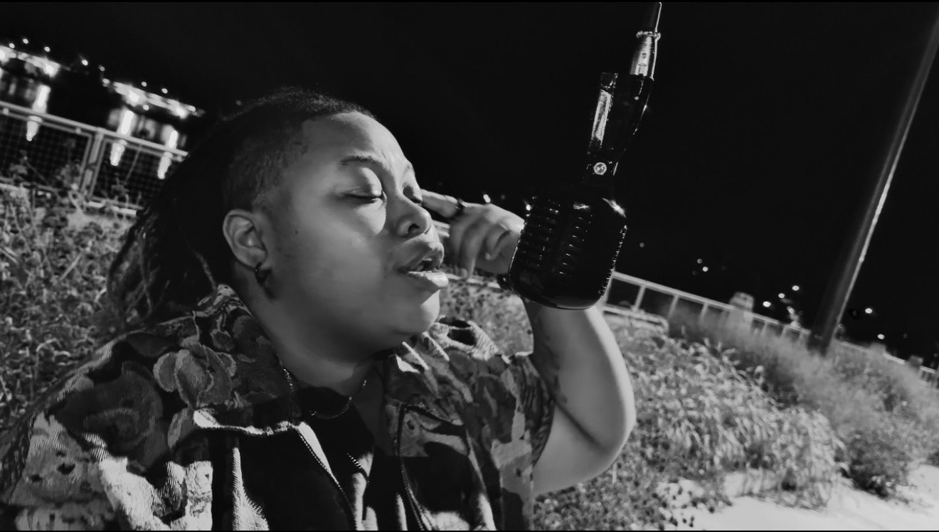 Black and white: CreNaetive singing eyes closed into a vintage microphone